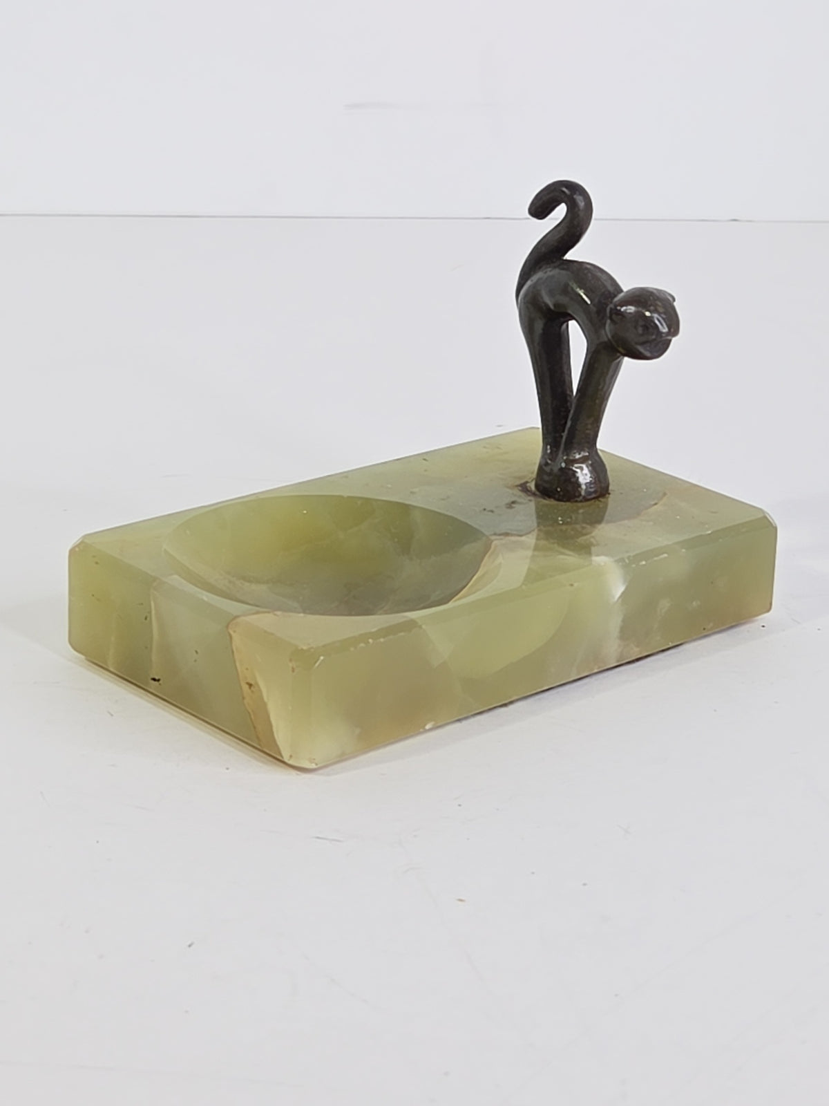 Oddly Darling Vintage green onyx trinket tray with a dark metal cat figurine in a playful arching pose.