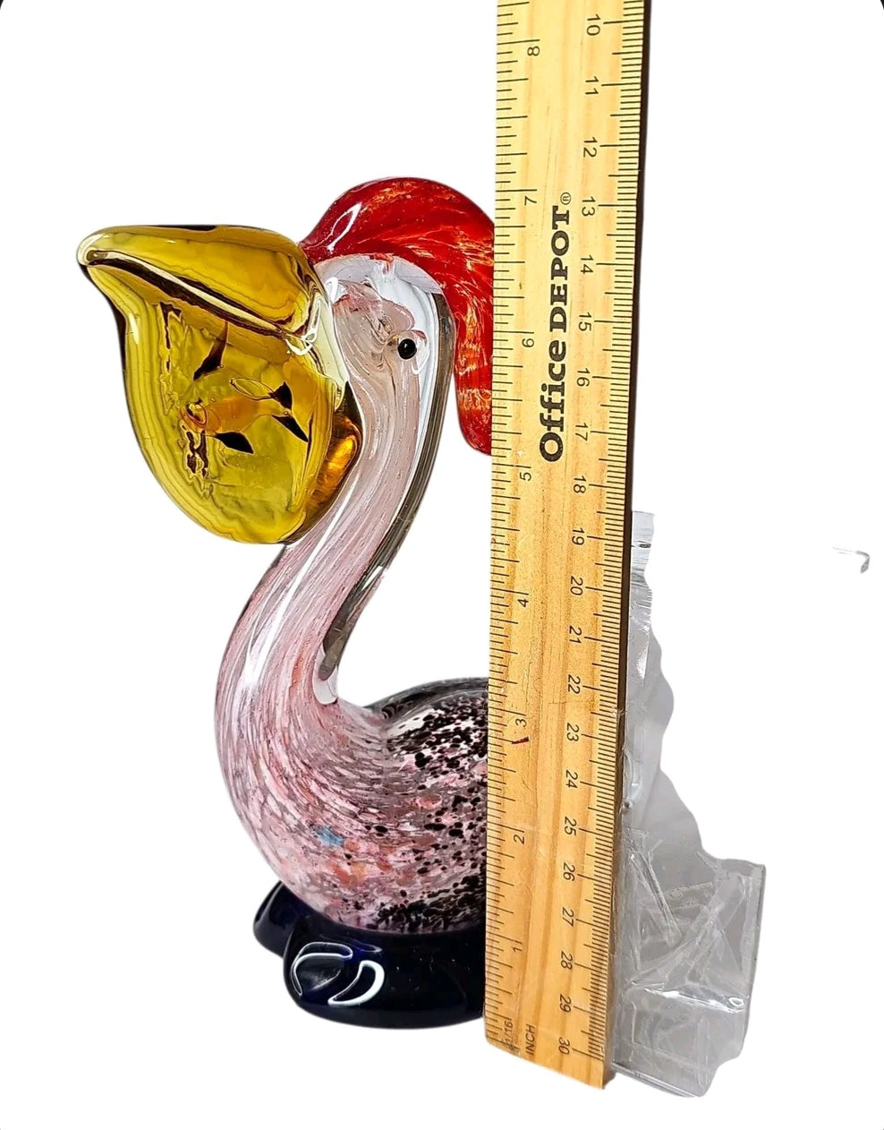 Oddly Darling Vintage hand blown glass pelican figurine with yellow beak, red crest, and pink speckled body on blue base