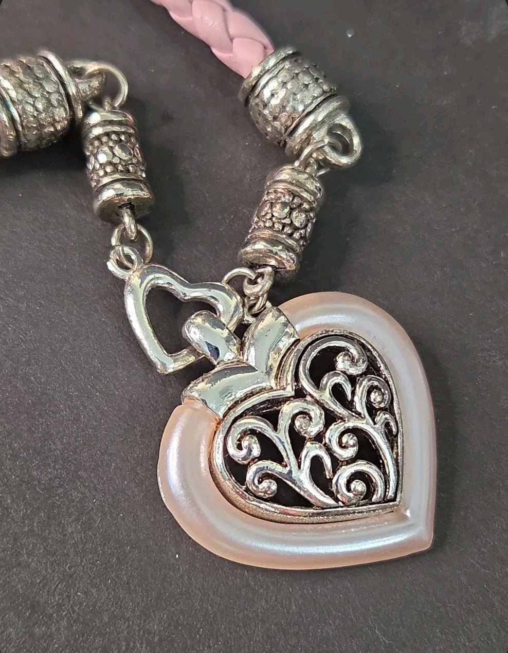 Oddly Darling Vintage heart pendant necklace with silver filigree, pearlescent pink border, and braided light pink cord.