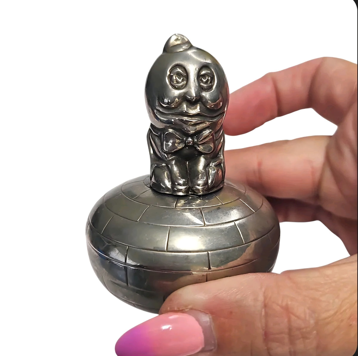 Oddly Darling Vintage silver Humpty Dumpty trinket box with a brick-patterned base held in a hand.
