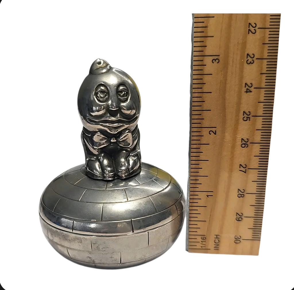 Oddly Darling Vintage silver-toned Humpty Dumpty trinket box with a brick-patterned base next to a wooden ruler.