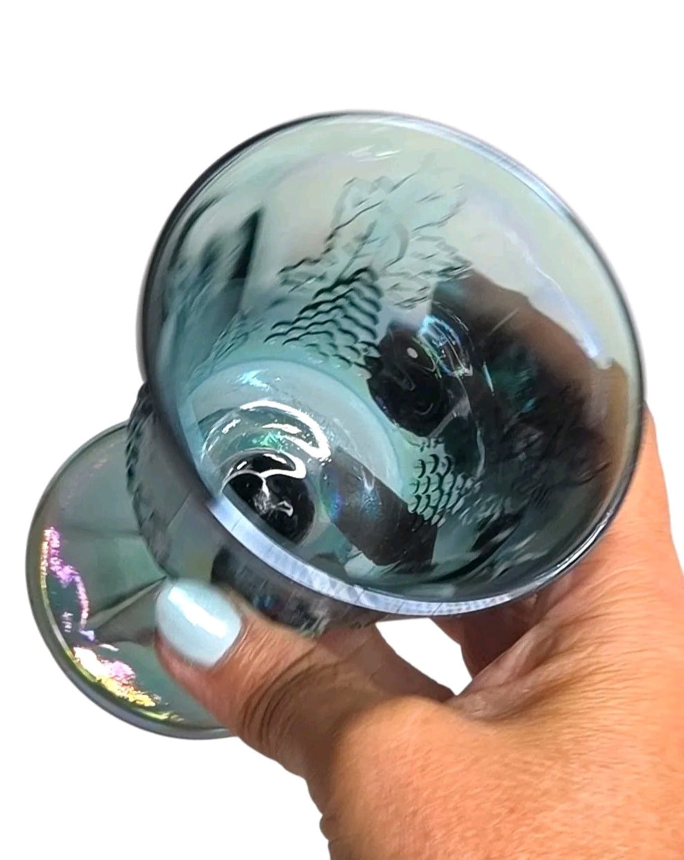 Oddly Darling Vintage iridescent blue carnival glass goblet with embossed grape and vine motif held in a hand