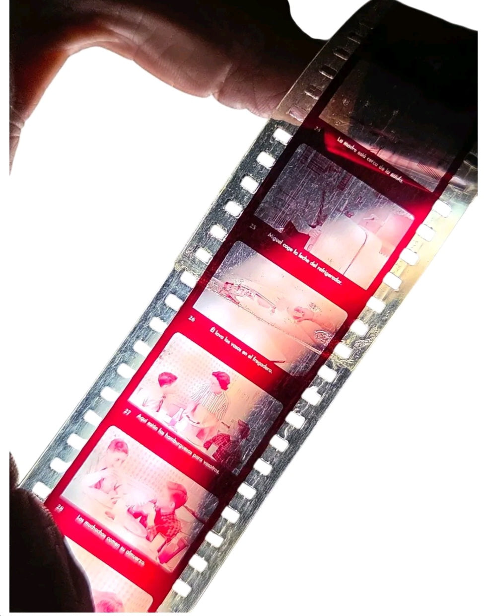Oddly Darling Vintage McGraw-Hill Spanish educational filmstrip held up to light showing retro classroom imagery