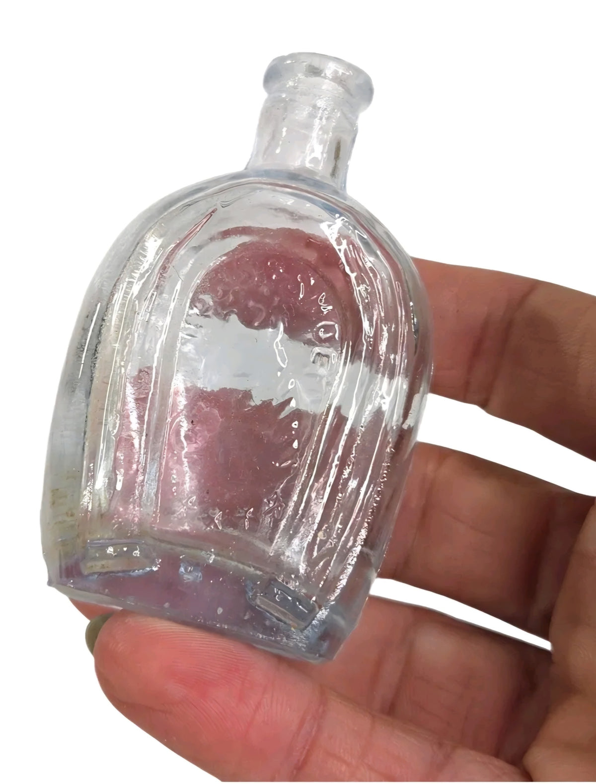 Oddly Darling Vintage miniature pale blue glass bottle with embossed detailing held in a hand
