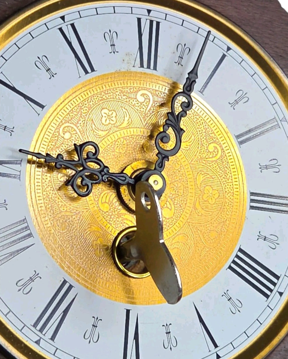 Oddly Darling Vintage octagonal mantel clock face with gold filigree center, Roman numerals, and ornate black hands.