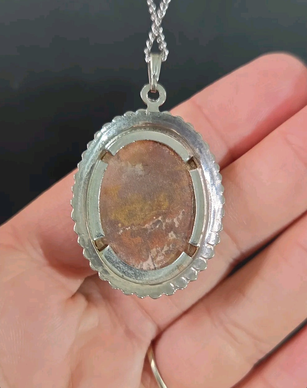 Oddly Darling Vintage oval agate pendant necklace featuring a silver-tone beaded frame held in a hand.