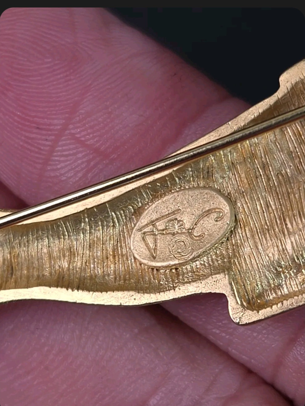 Oddly Darling Vintage gold-tone panther brooch showing the designer hallmark stamp on the textured metal back
