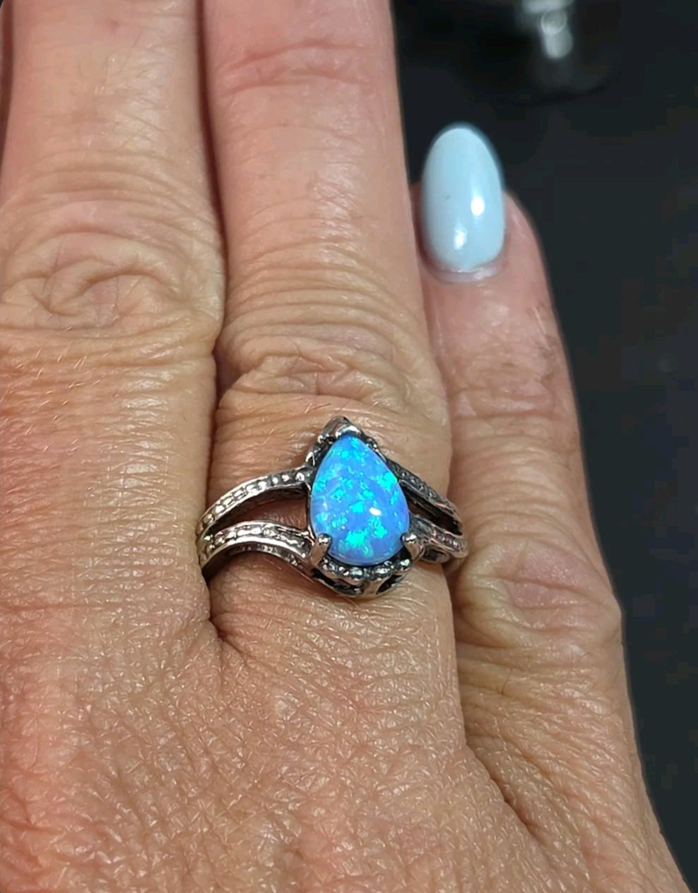 Oddly Darling Vintage pear-shaped blue opal statement ring with a textured silver-tone split-shank band on a finger.