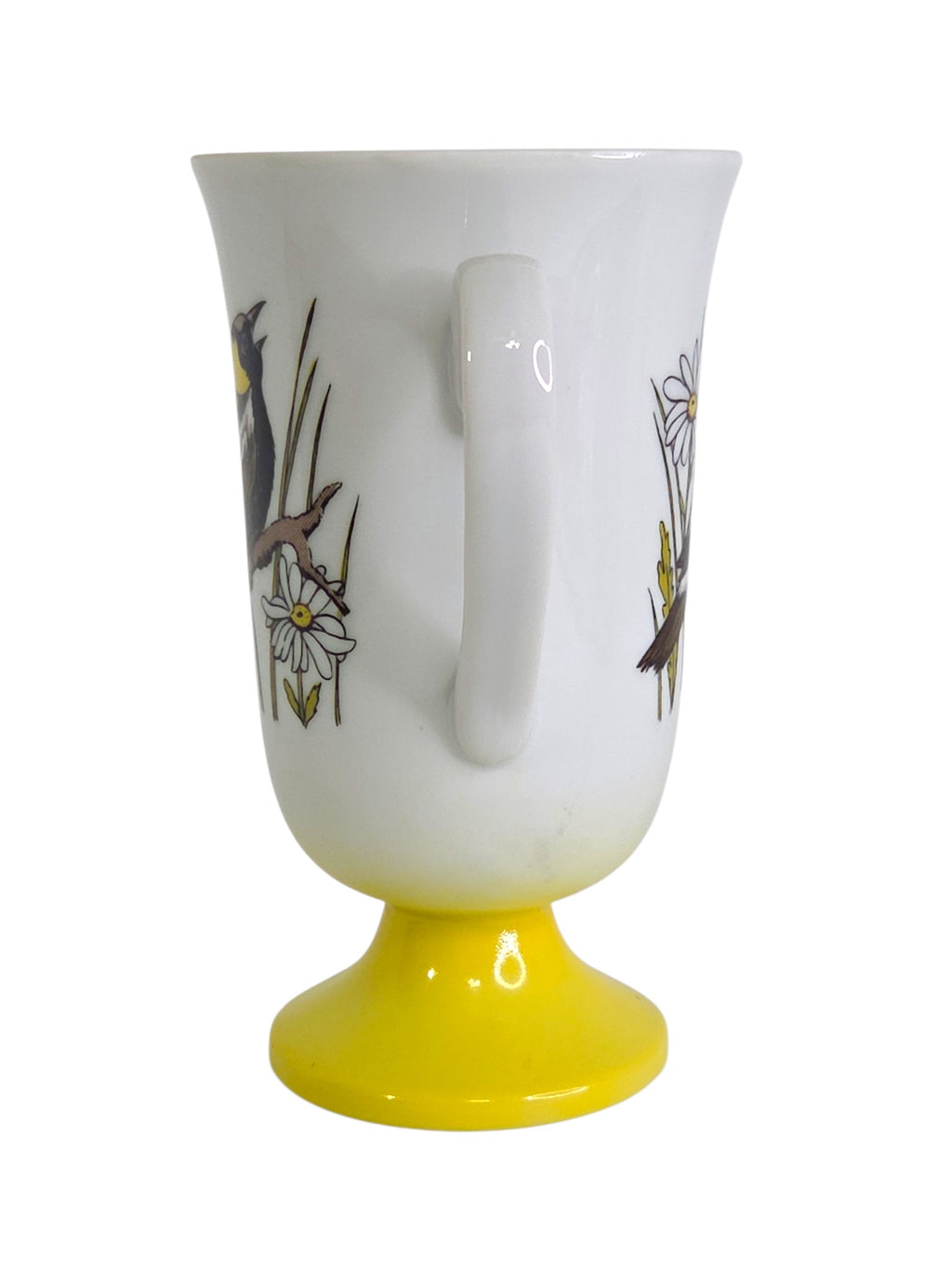 Oddly Darling Vintage white ceramic pedestal mug featuring a songbird and daisy illustration with a yellow base.