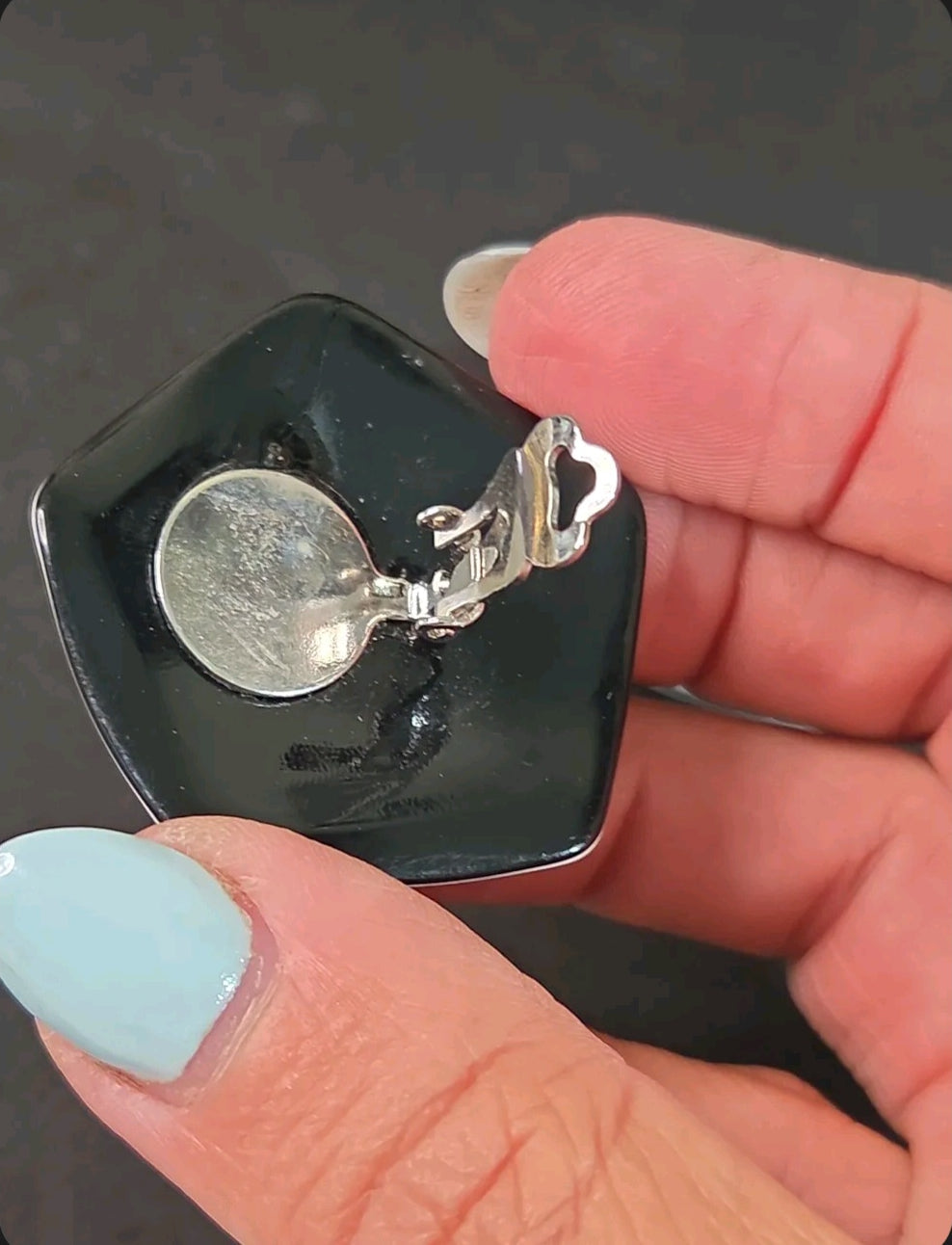 Oddly Darling Vintage pentagonal clip-on earring showing the silver metal clip mechanism on the black glossy back
