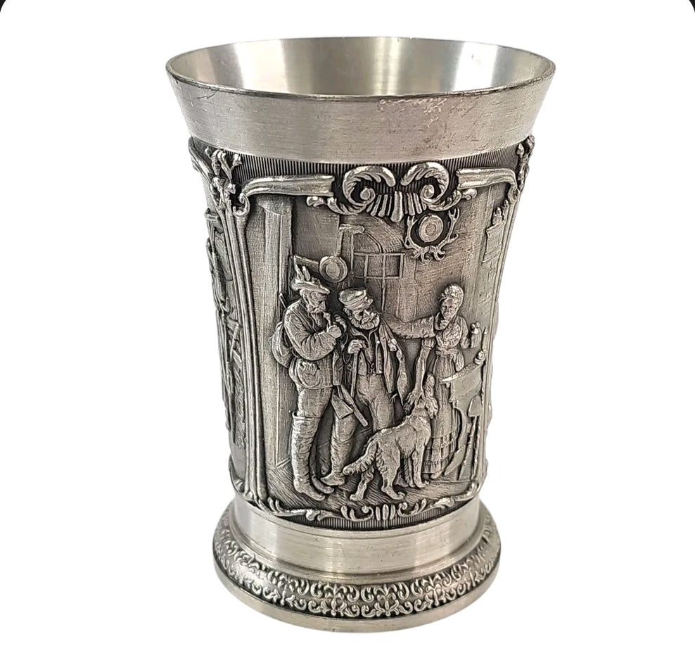 Oddly Darling Vintage SKS Zinn pewter beaker with intricate embossed rustic village scenes and a sturdy metal base.