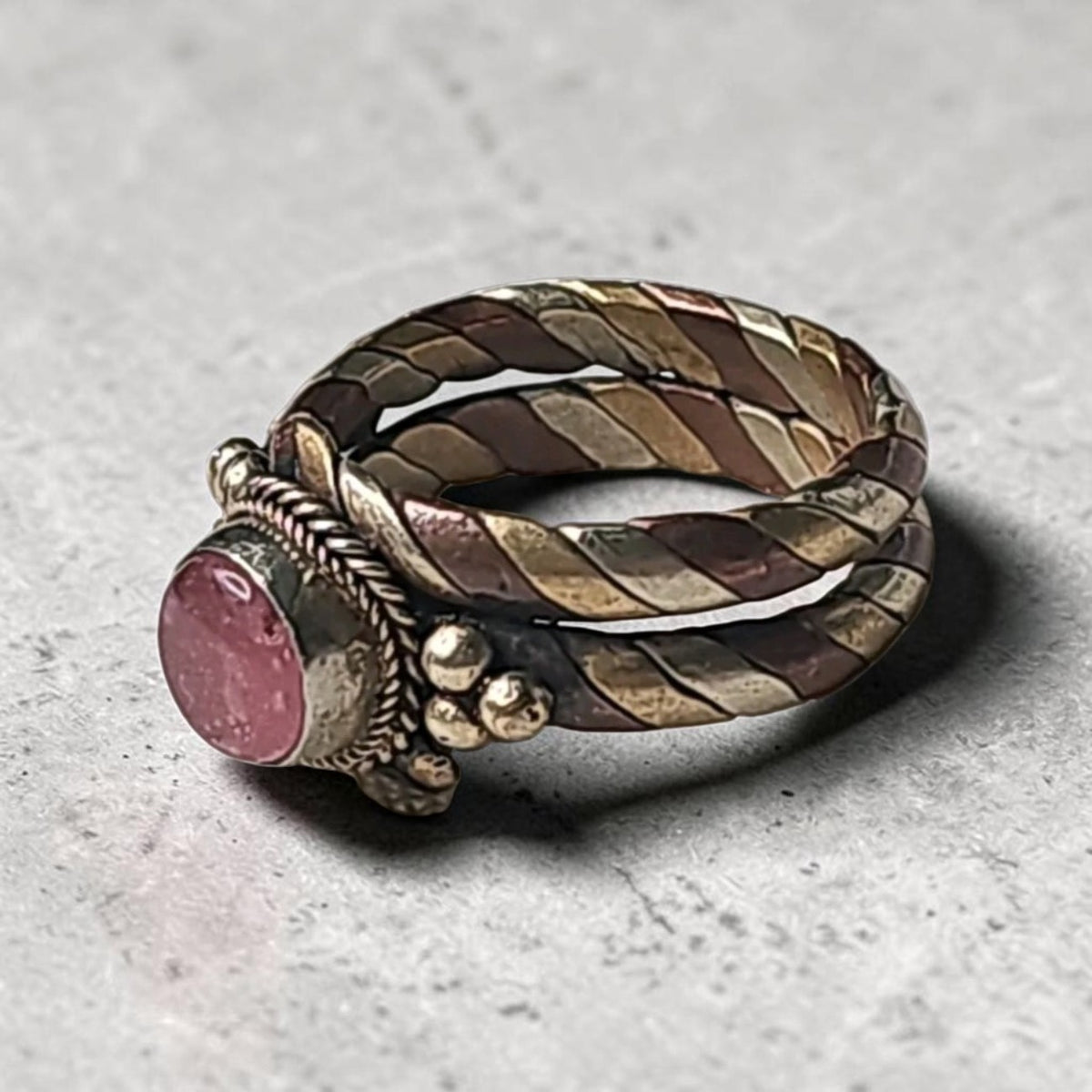 Oddly Darling Vintage twisted metal band ring featuring a pink cabochon stone with copper and brass rope detailing.