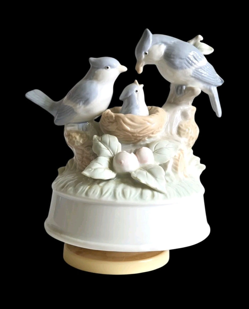 Oddly Darling Vintage porcelain music box featuring a bird family in a nest with soft pastel blue and cream tones.