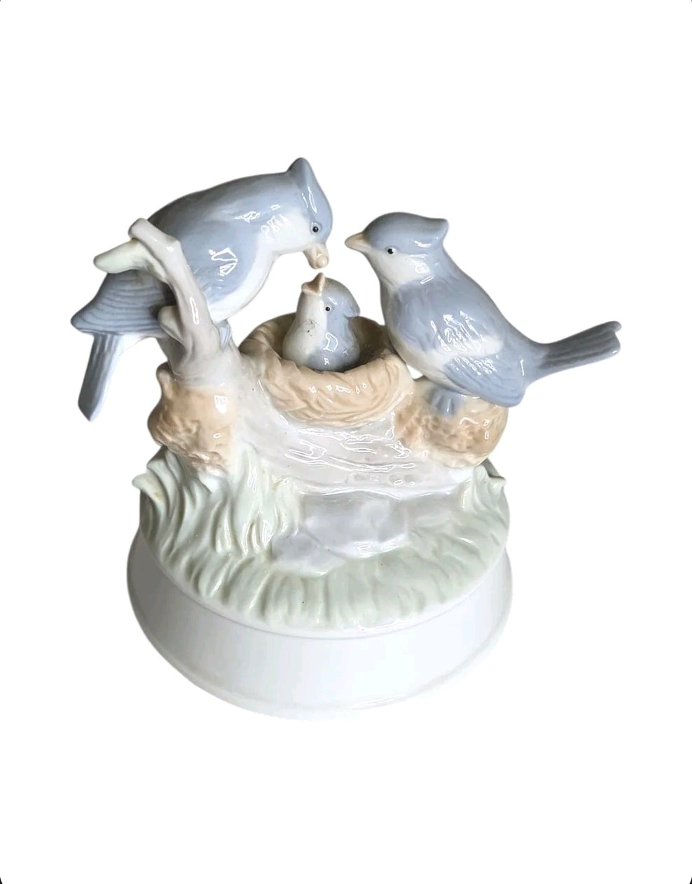 Oddly Darling Vintage porcelain music box featuring a blue bird family in a nest with soft pastel tones.