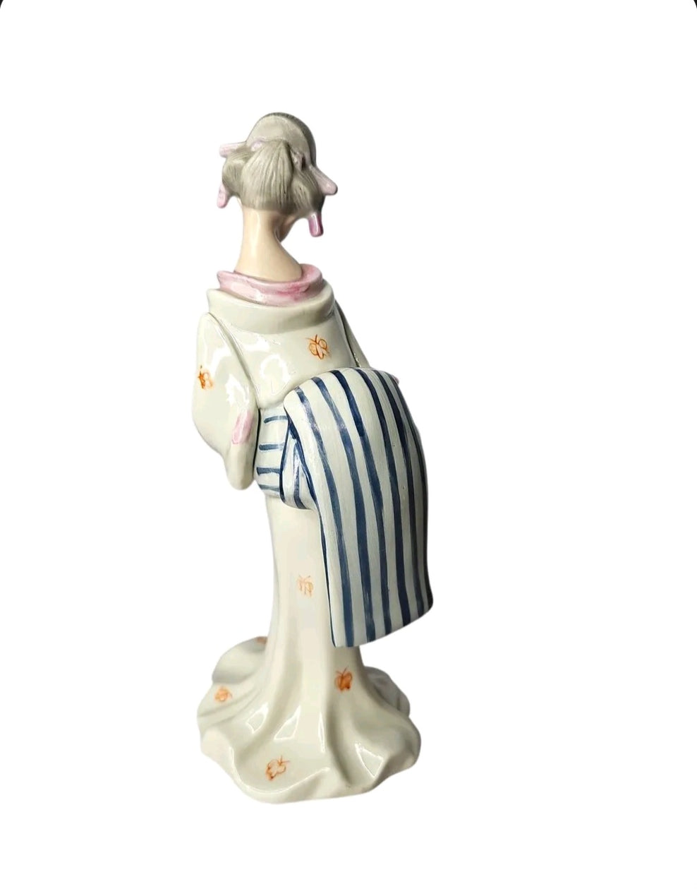 Oddly Darling Vintage porcelain geisha figurine in a cream kimono with blue striped obi, viewed from the back.