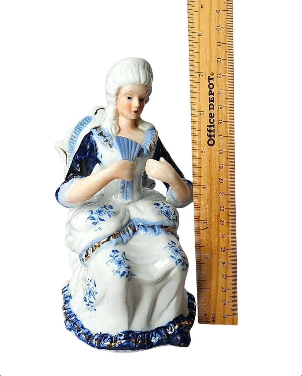 Oddly Darling Vintage porcelain lady figurine in a blue and white floral gown with gold trim, seated with a fan.