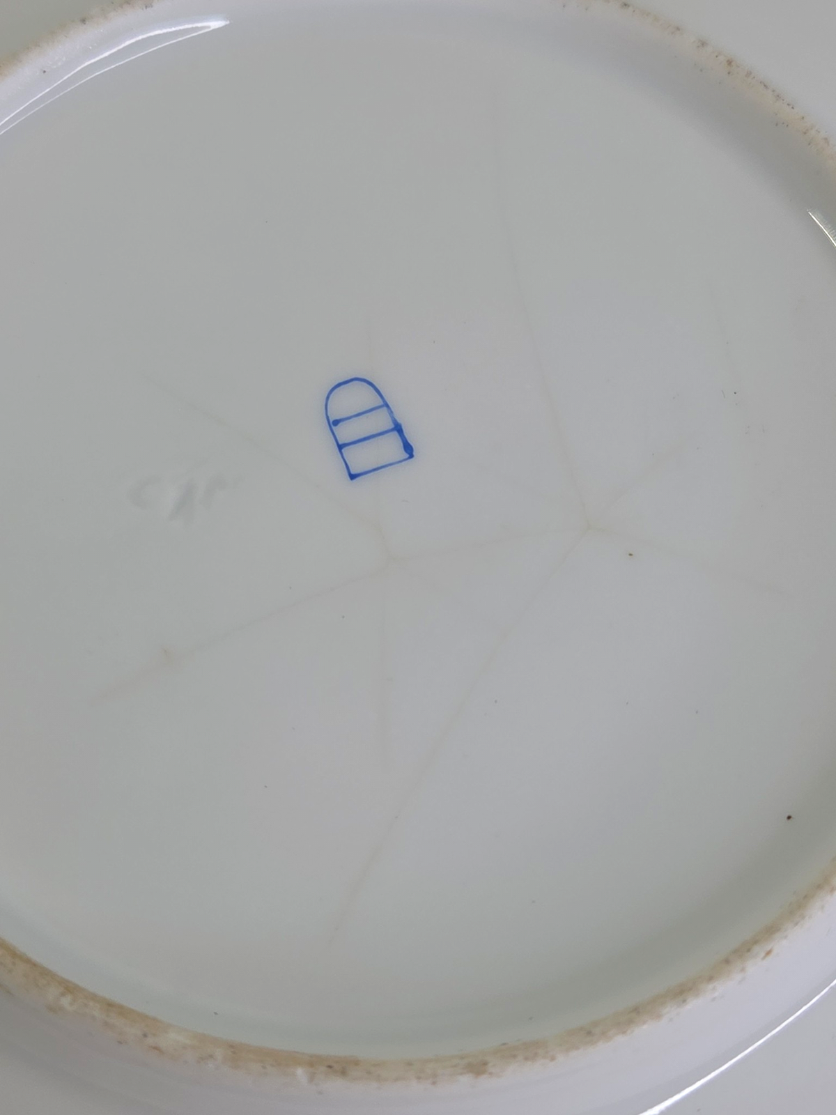Oddly Darling Vintage porcelain plate base showing a blue maker mark and fine crazing on the white ceramic surface