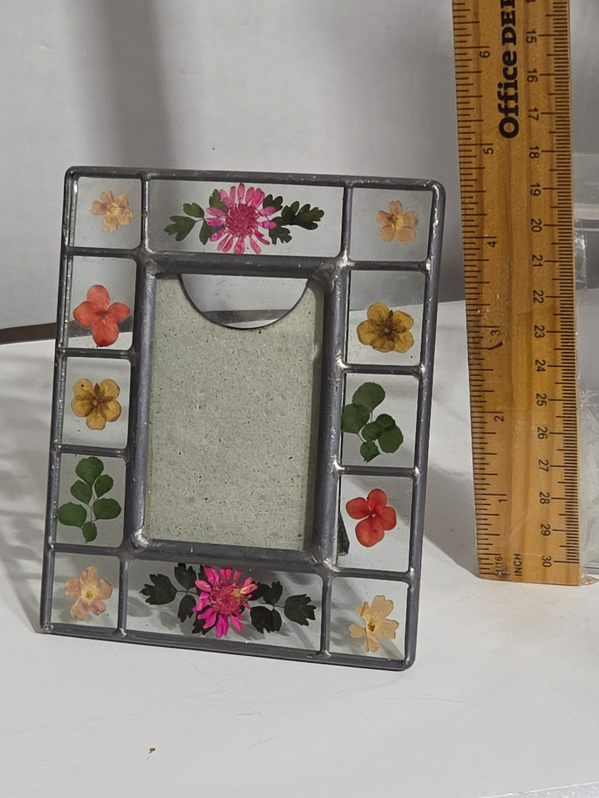 Oddly Darling Vintage pressed flower picture frame with stained-glass style metal border and colorful floral accents.