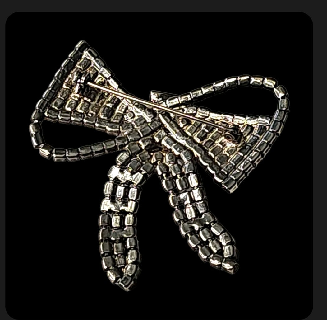 Oddly Darling Vintage crystal bow brooch with shimmering rhinestones and a secure pin backing on a black background.