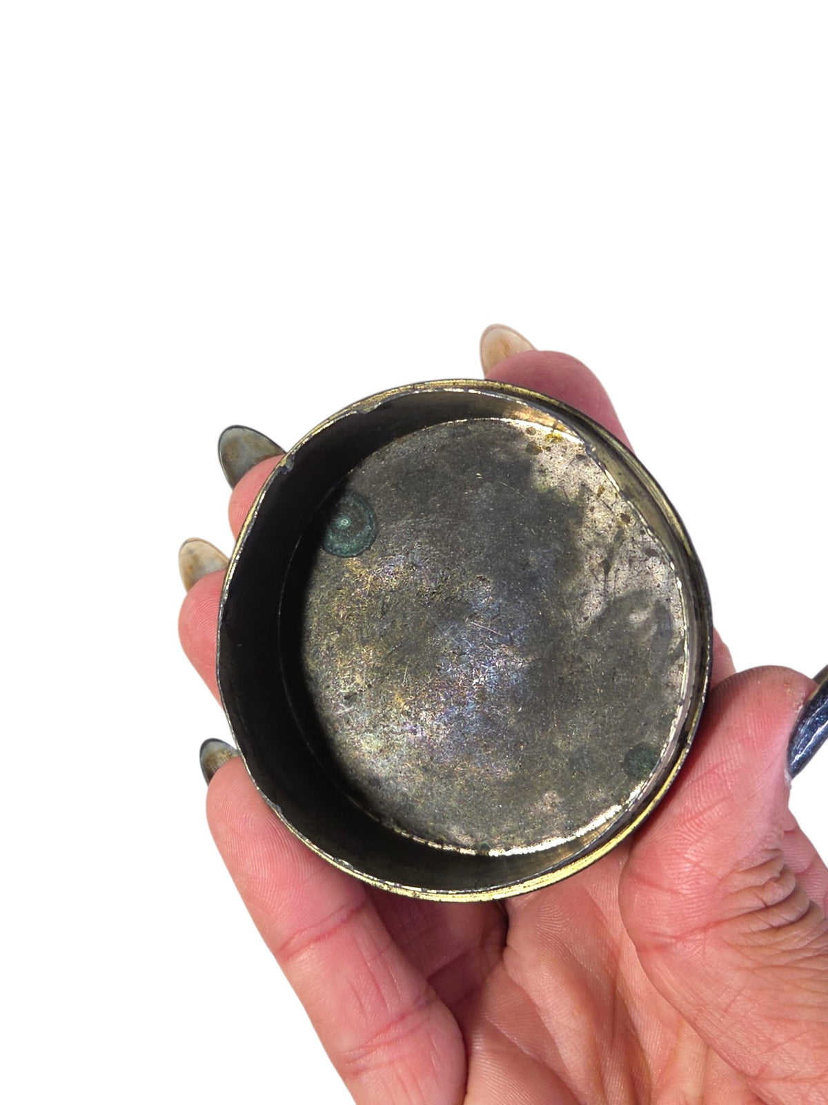 Inside of the vintage peacock box showing silvery patina, tarnish and green corrosion spots