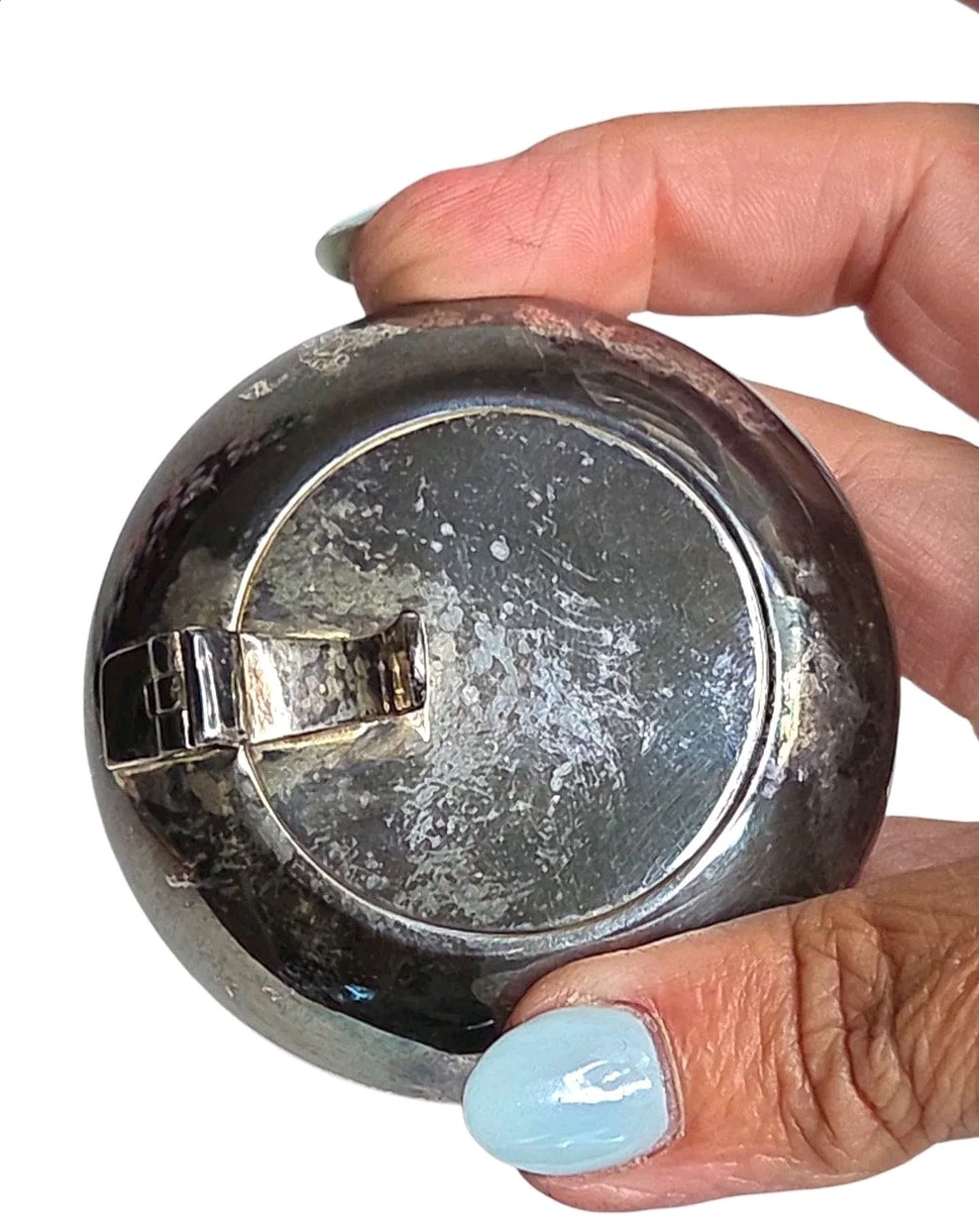 Oddly Darling Vintage round silver trinket box with a weathered patina held in a hand with light blue nail polish