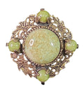 Oddly Darling Vintage brooch featuring a sage-green mottled cabochon in an antique-gold leaf and acorn metal frame.