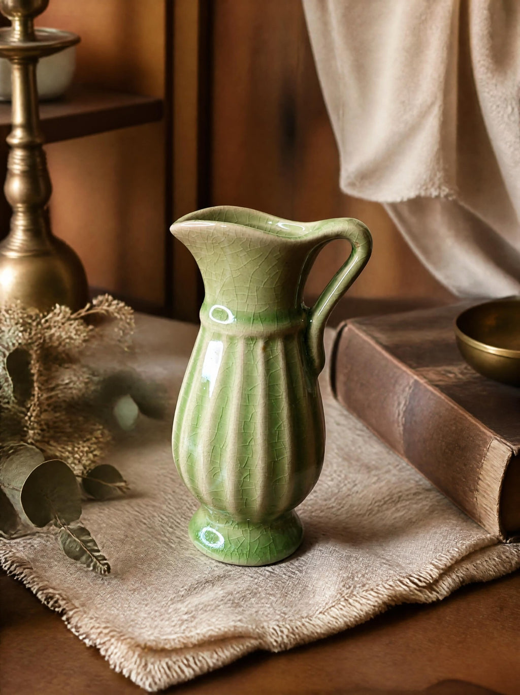 Oddly Darling Vintage sage green ceramic pitcher vase with a ribbed texture and crackle glaze finish on a table.