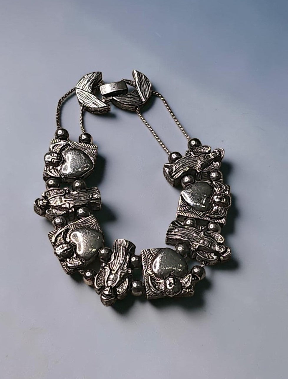 Oddly Darling Vintage silver-tone charm bracelet with sculpted angel figures and polished heart motifs.
