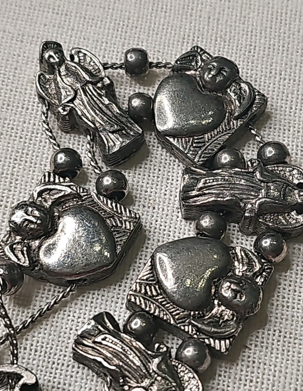 Oddly Darling Vintage silver-tone charm bracelet featuring alternating sculpted angel figures and polished heart motifs.