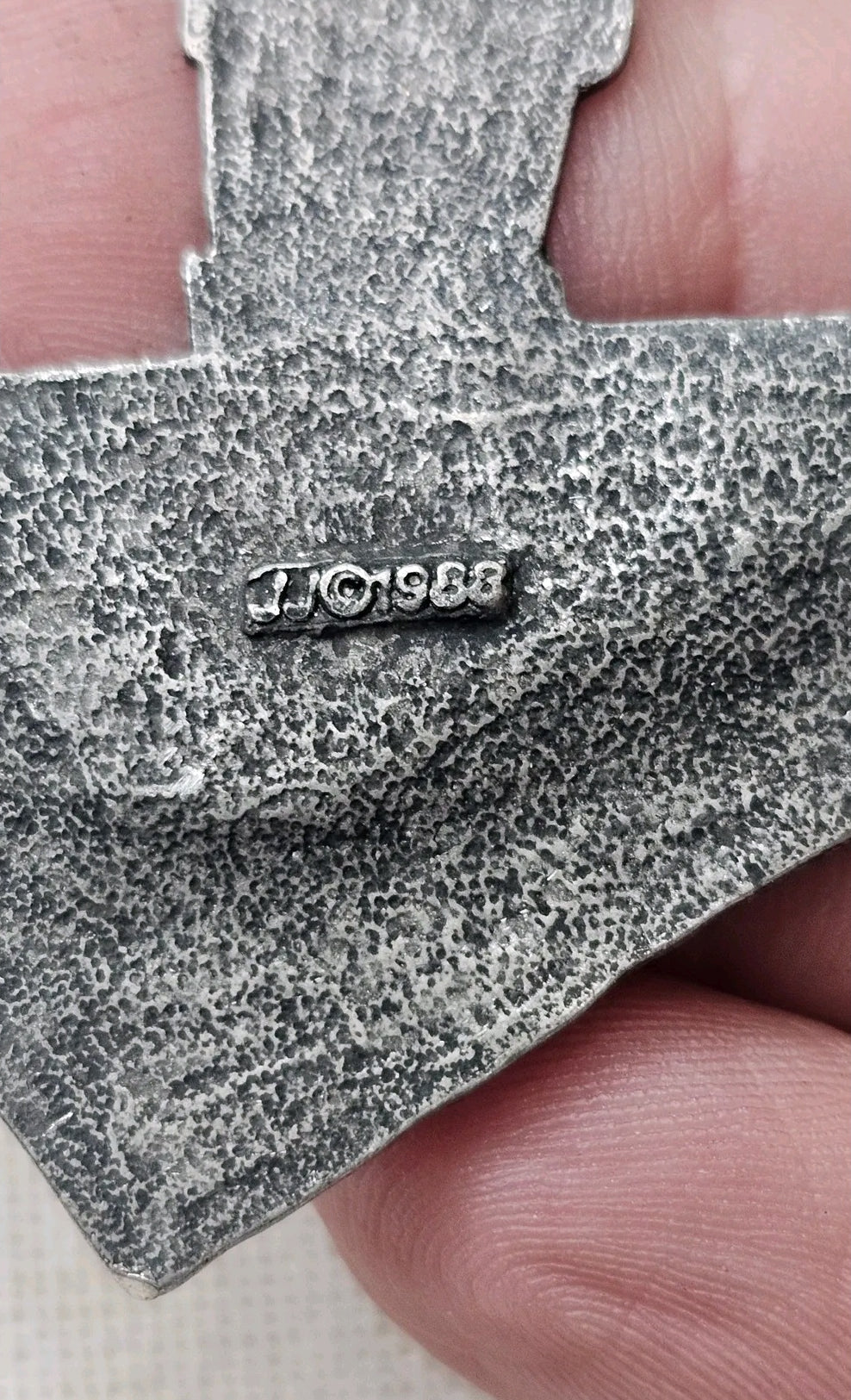 Oddly Darling Vintage silver-tone metal brooch showing the 1988 JJ copyright mark on the textured back of the pin.
