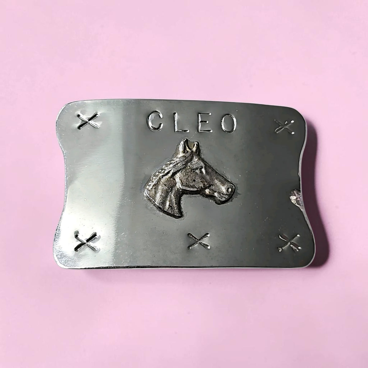 Oddly Darling Vintage silver-tone belt buckle with a horse head relief and the name CLEO on a pink background.