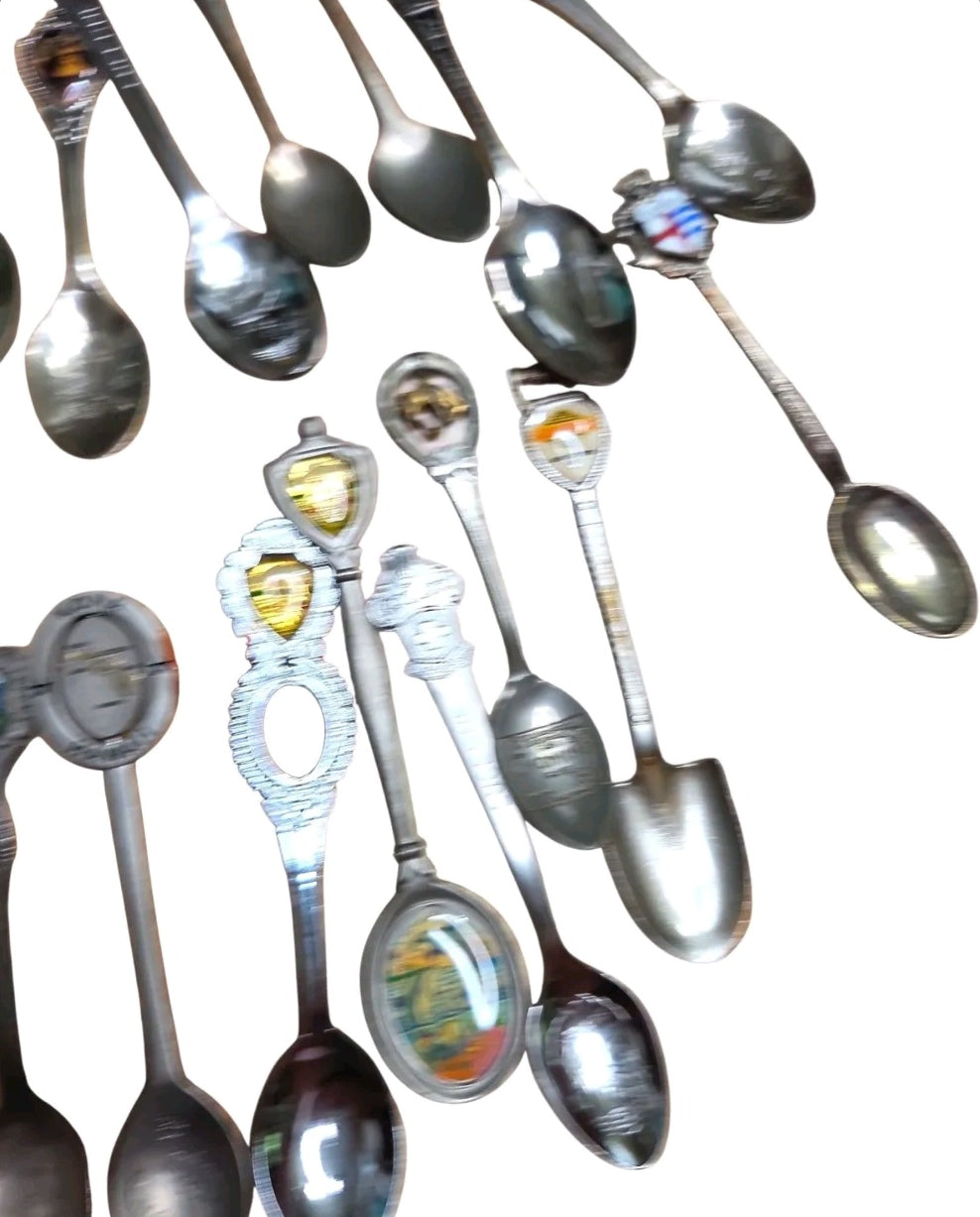 Oddly Darling Vintage collection of assorted metal souvenir spoons featuring intricate handles and enamel details.