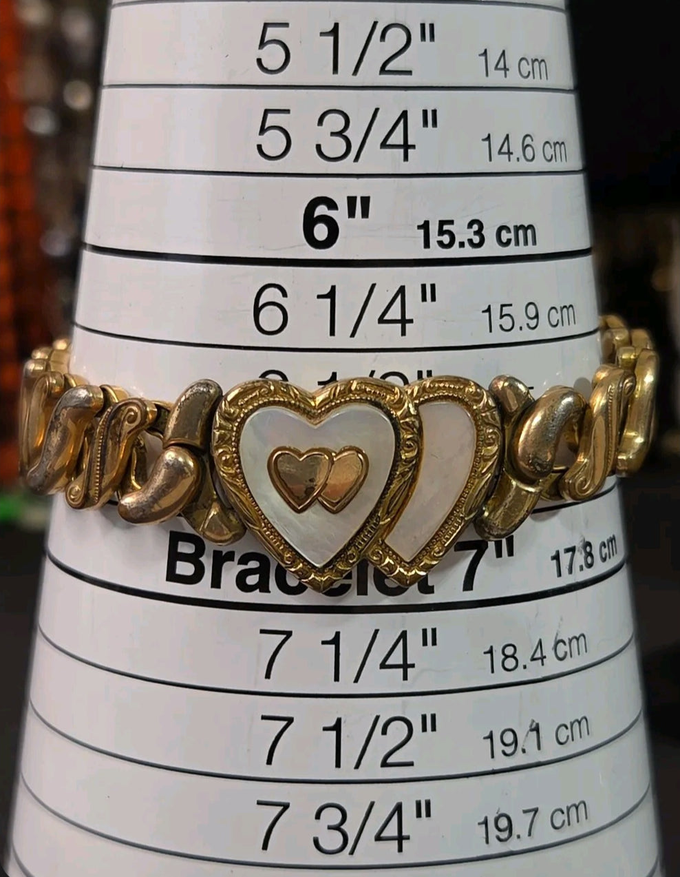 Oddly Darling Vintage Speidel gold-tone expansion bracelet featuring dual hearts with mother-of-pearl inlay on a sizer