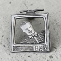 Oddly Darling Vintage silver-tone metal brooch featuring a retro television set with a stylized character inside.