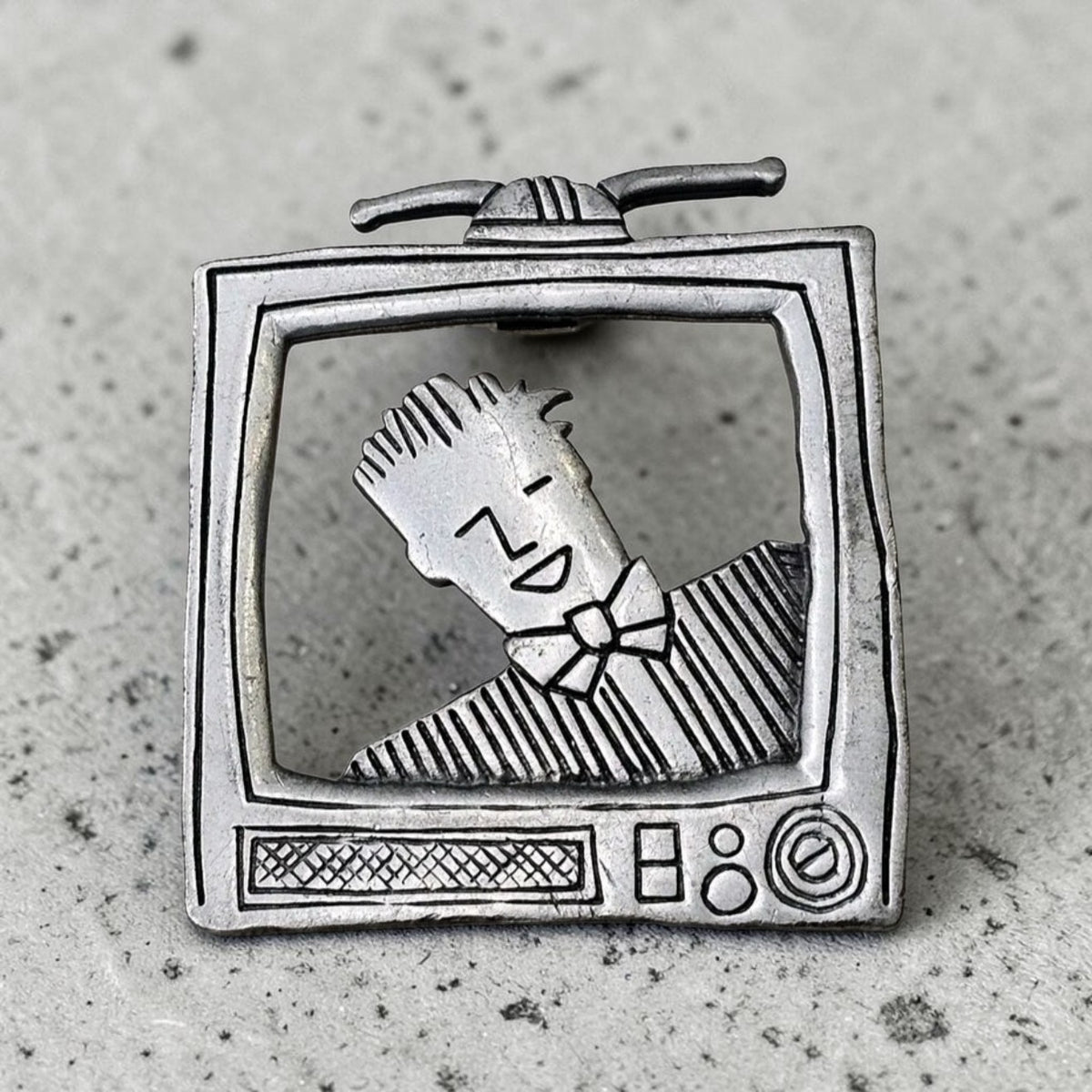 Oddly Darling Vintage silver-tone metal brooch featuring a retro television set with a stylized character inside.