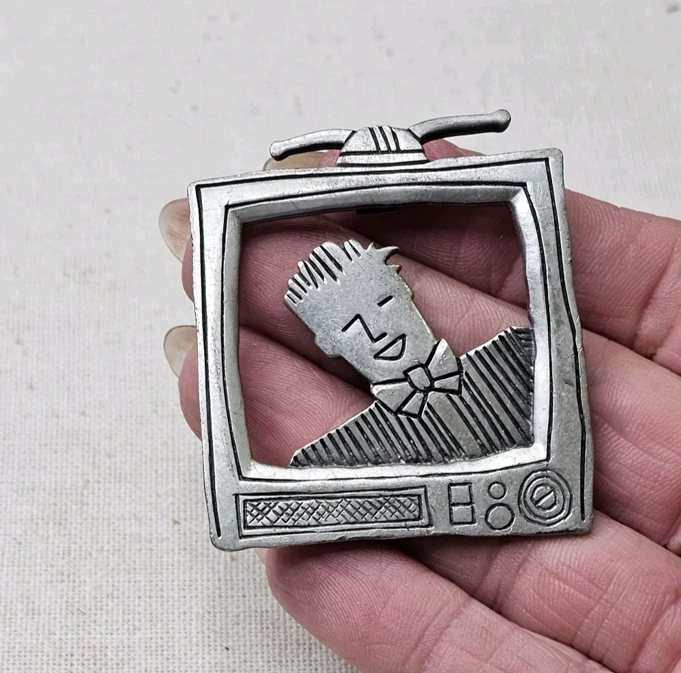 Oddly Darling Vintage silver-tone metal brooch featuring a retro television set with a character on the screen.