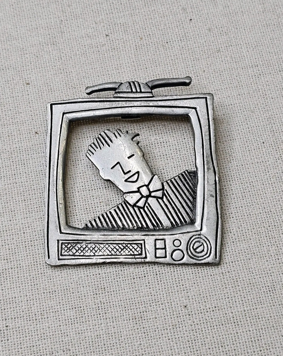 Oddly Darling Vintage silver-tone metal brooch featuring a retro television set with a character on the screen.