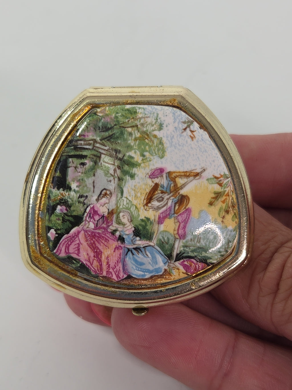 Oddly Darling Vintage gold-tone triangular ring compact featuring a colorful pastoral garden scene on the lid