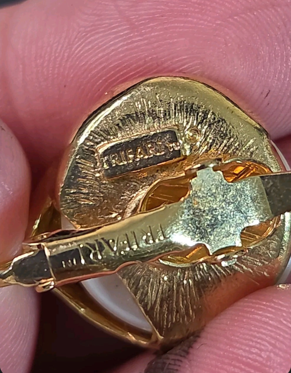Oddly Darling Vintage Trifari clip-on earring back showing the signature stamp on the gold-tone metal setting