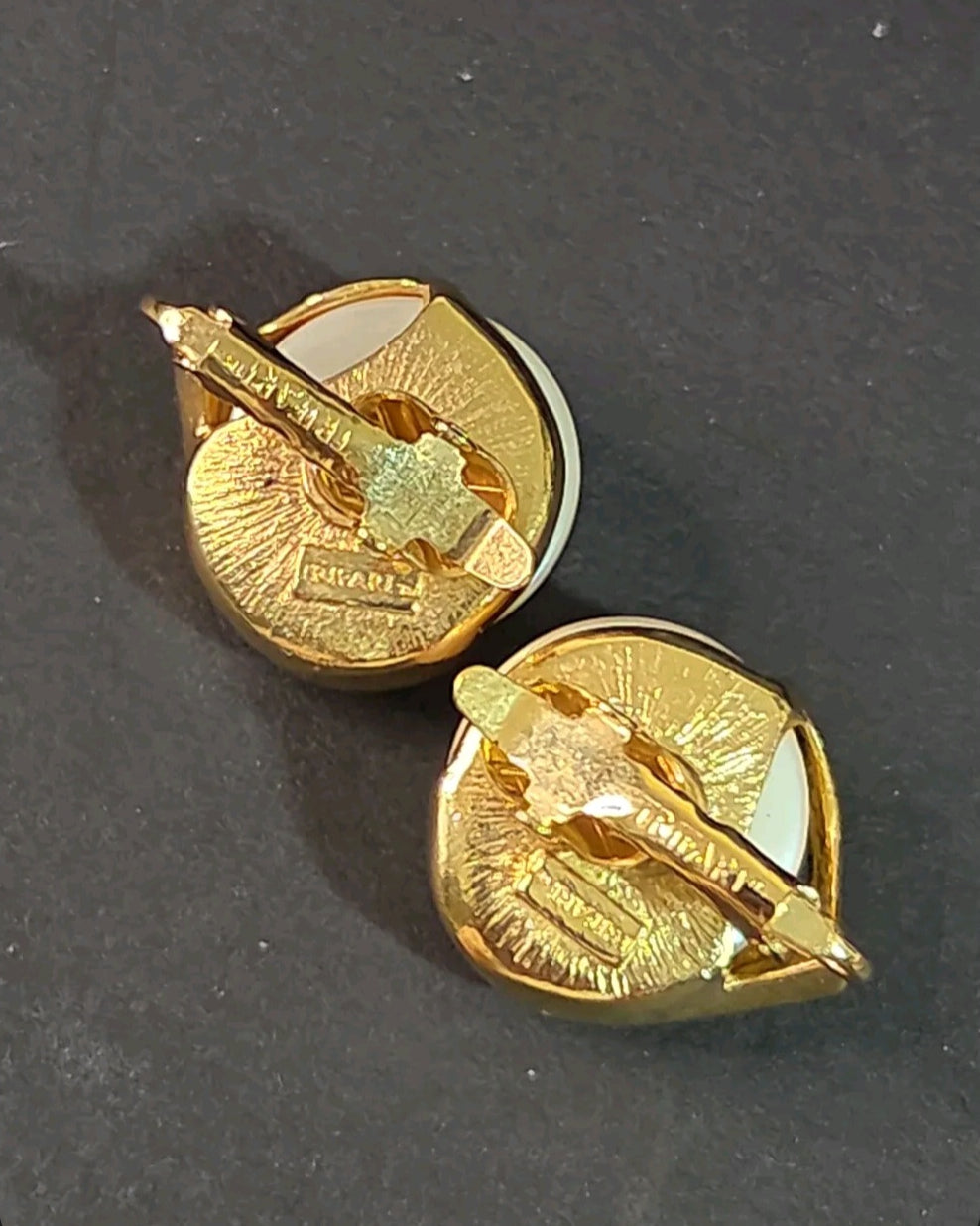 Oddly Darling Vintage Trifari clip-on earrings showing the gold-tone metal backs with signature Trifari branding