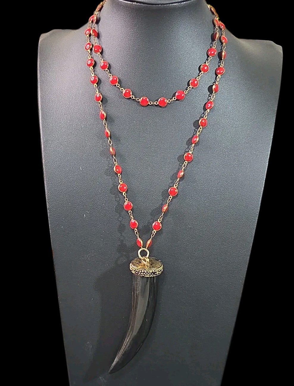 Oddly Darling Vintage long necklace with a black horn tusk pendant and vibrant red beaded rosary-style chain.