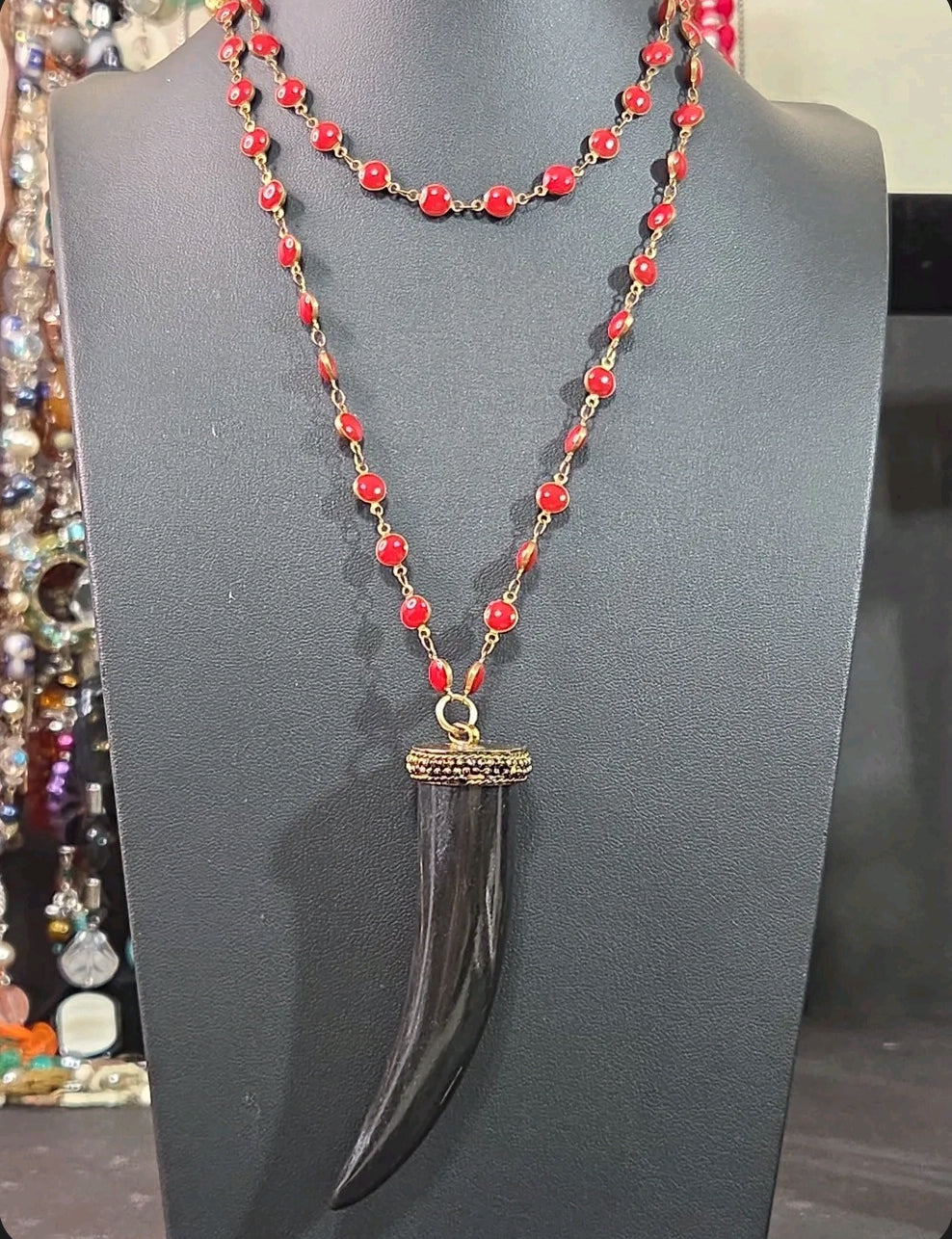 Oddly Darling Vintage long necklace with a black tusk pendant, gold-tone cap, and vibrant red circular enamel beads.