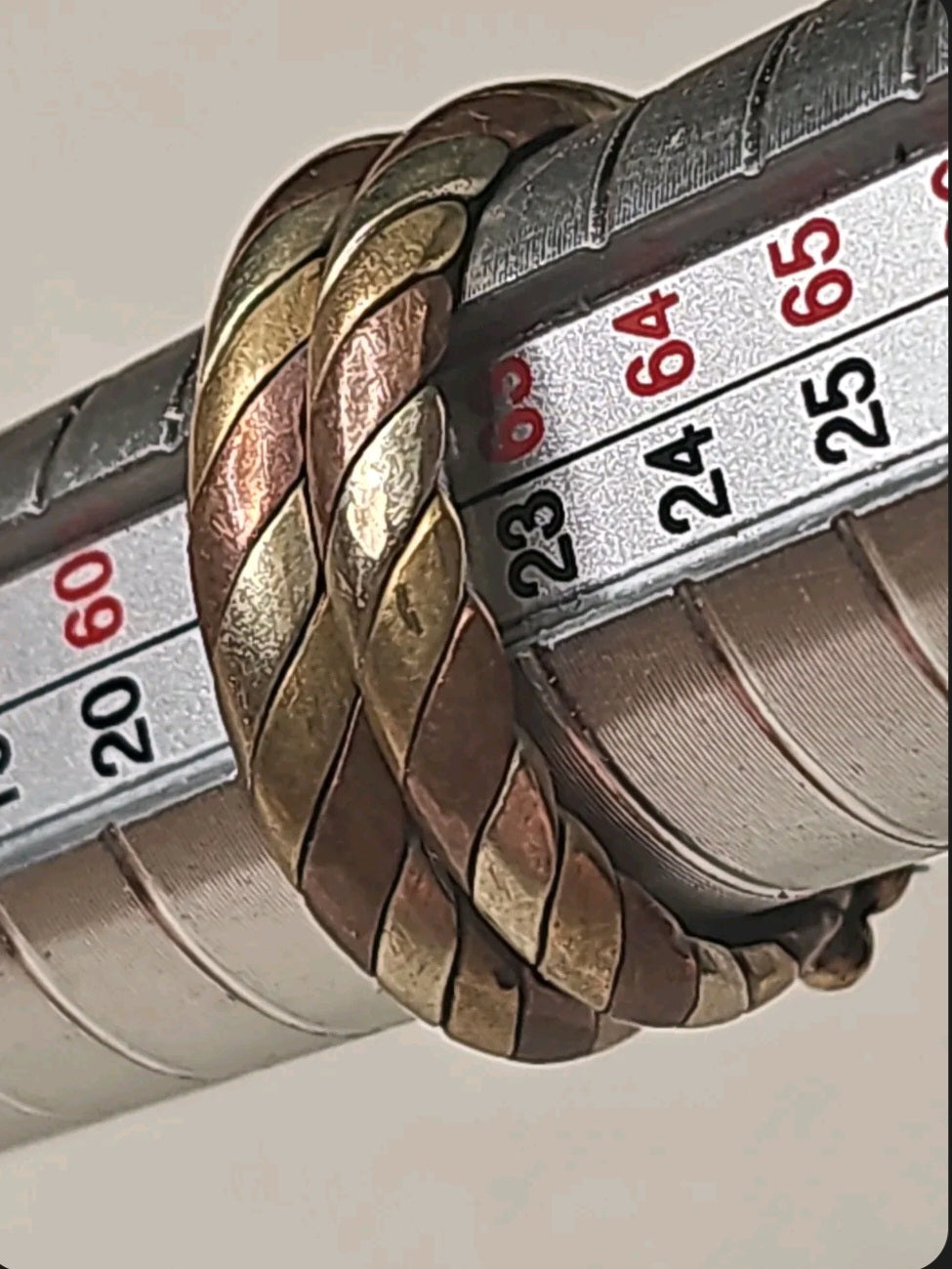 Oddly Darling Vintage twisted metal band ring featuring layered copper and brass rope-style textures on a ring sizer.