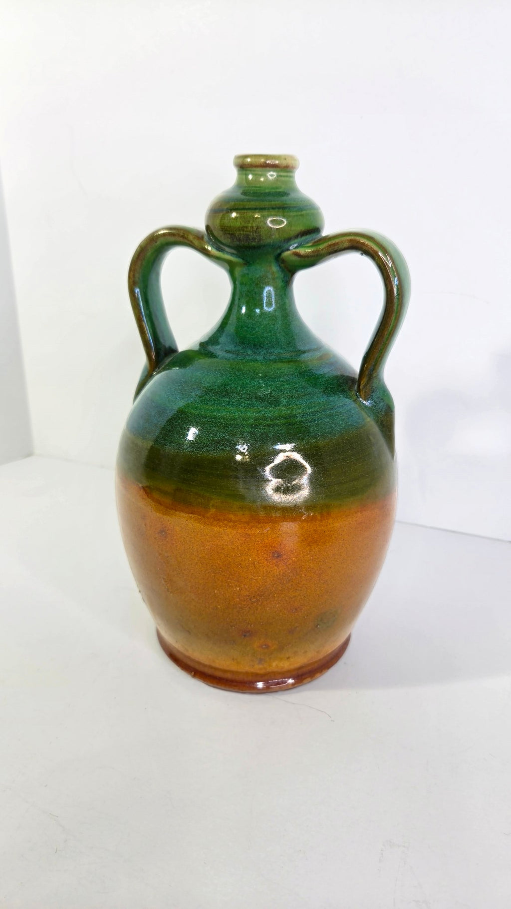 Oddly Darling Vintage handcrafted ceramic jug featuring a two-tone forest green and amber-brown glossy glaze.