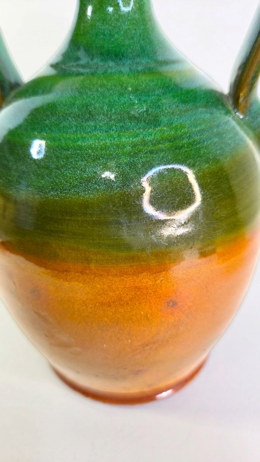 Oddly Darling Vintage handcrafted ceramic jug with a two-tone forest green and amber-brown glossy glaze and handles.