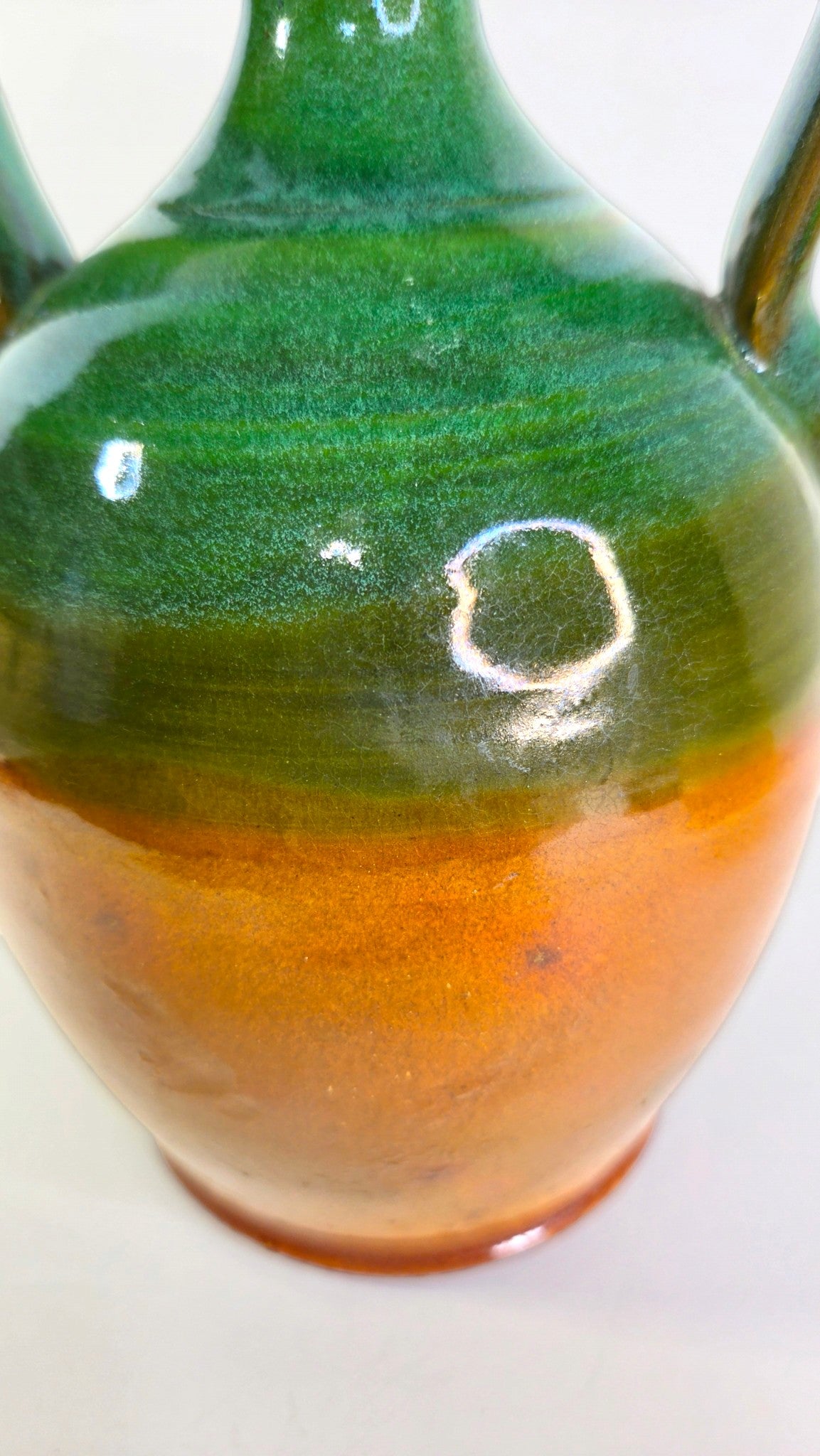 Oddly Darling Vintage handcrafted ceramic jug with a two-tone forest green and amber-brown glossy glaze and handles.