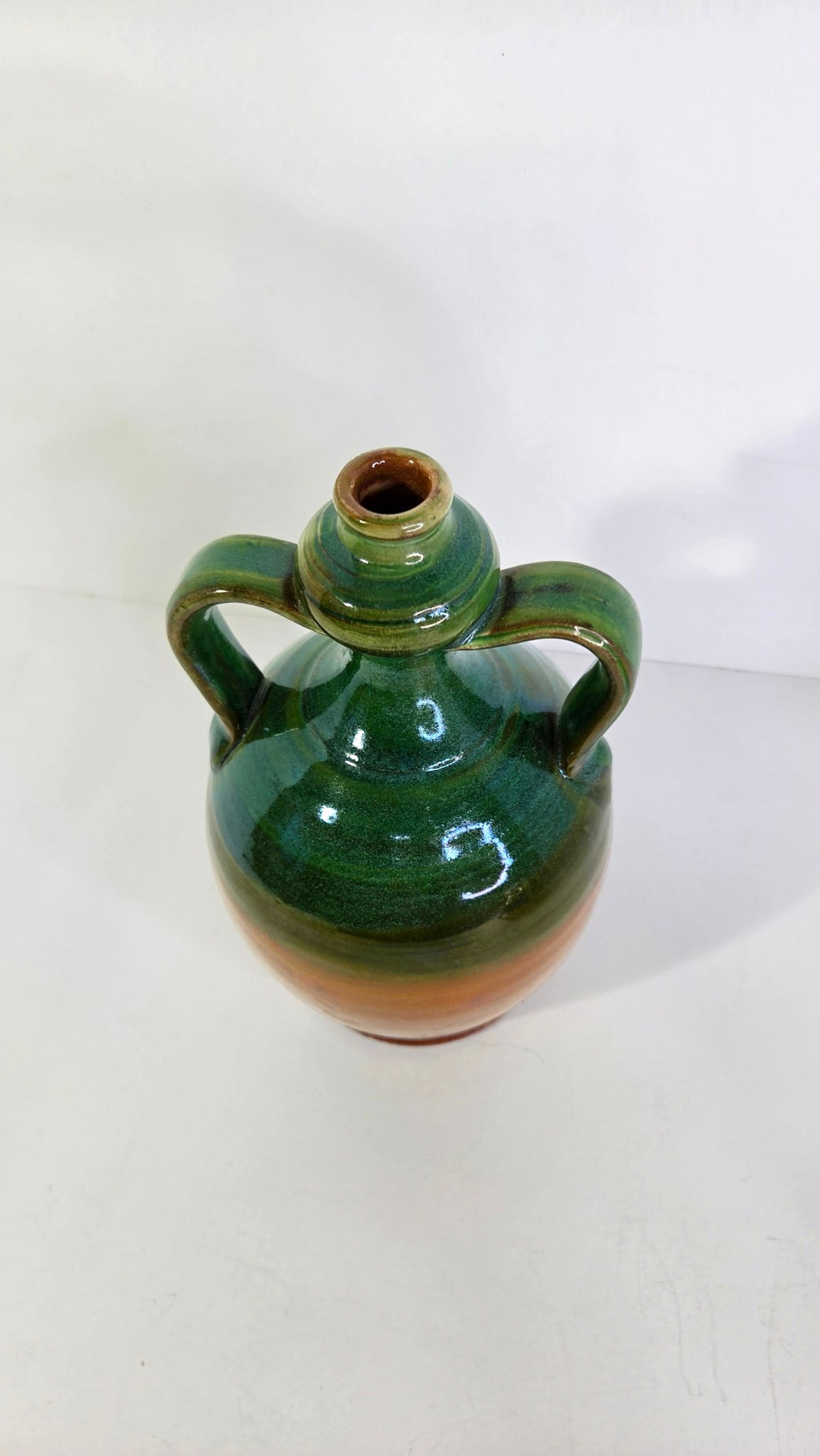 Oddly Darling Vintage handcrafted ceramic jug with dual handles, featuring a forest green and amber-brown glaze.