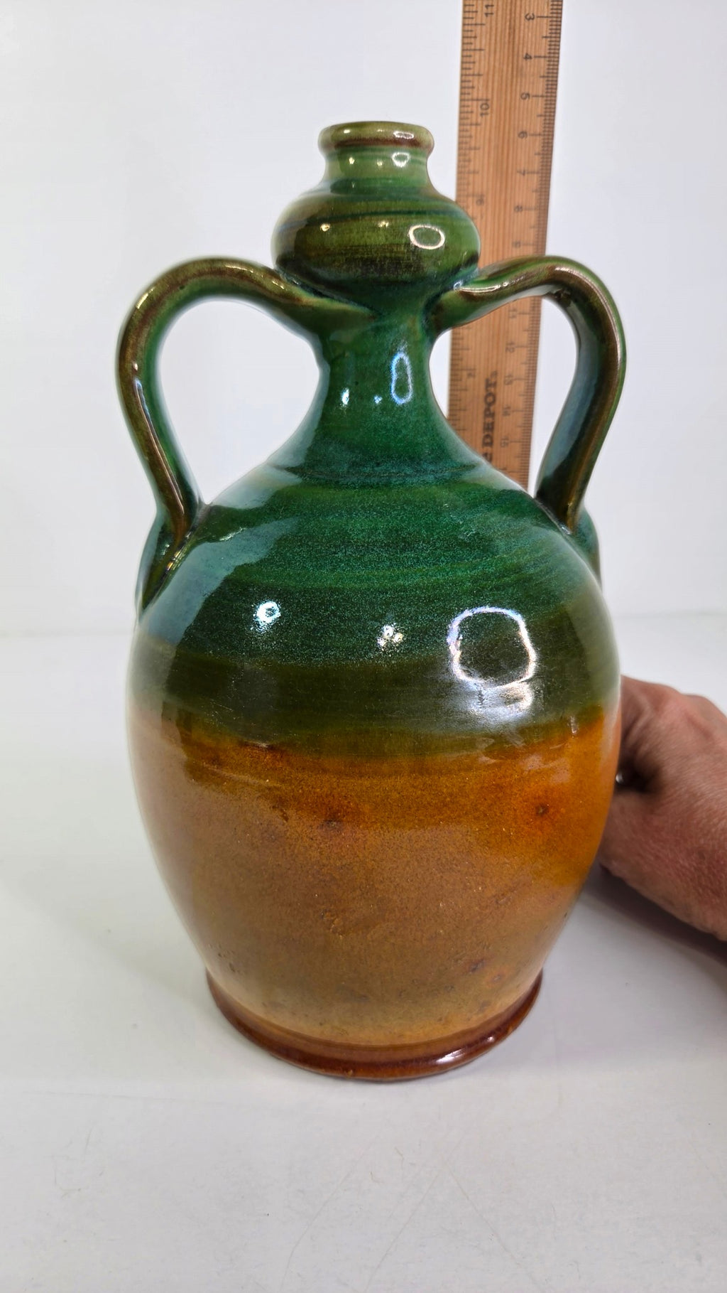 Oddly Darling Vintage handcrafted ceramic jug with two handles, featuring a forest green and amber-brown glaze.