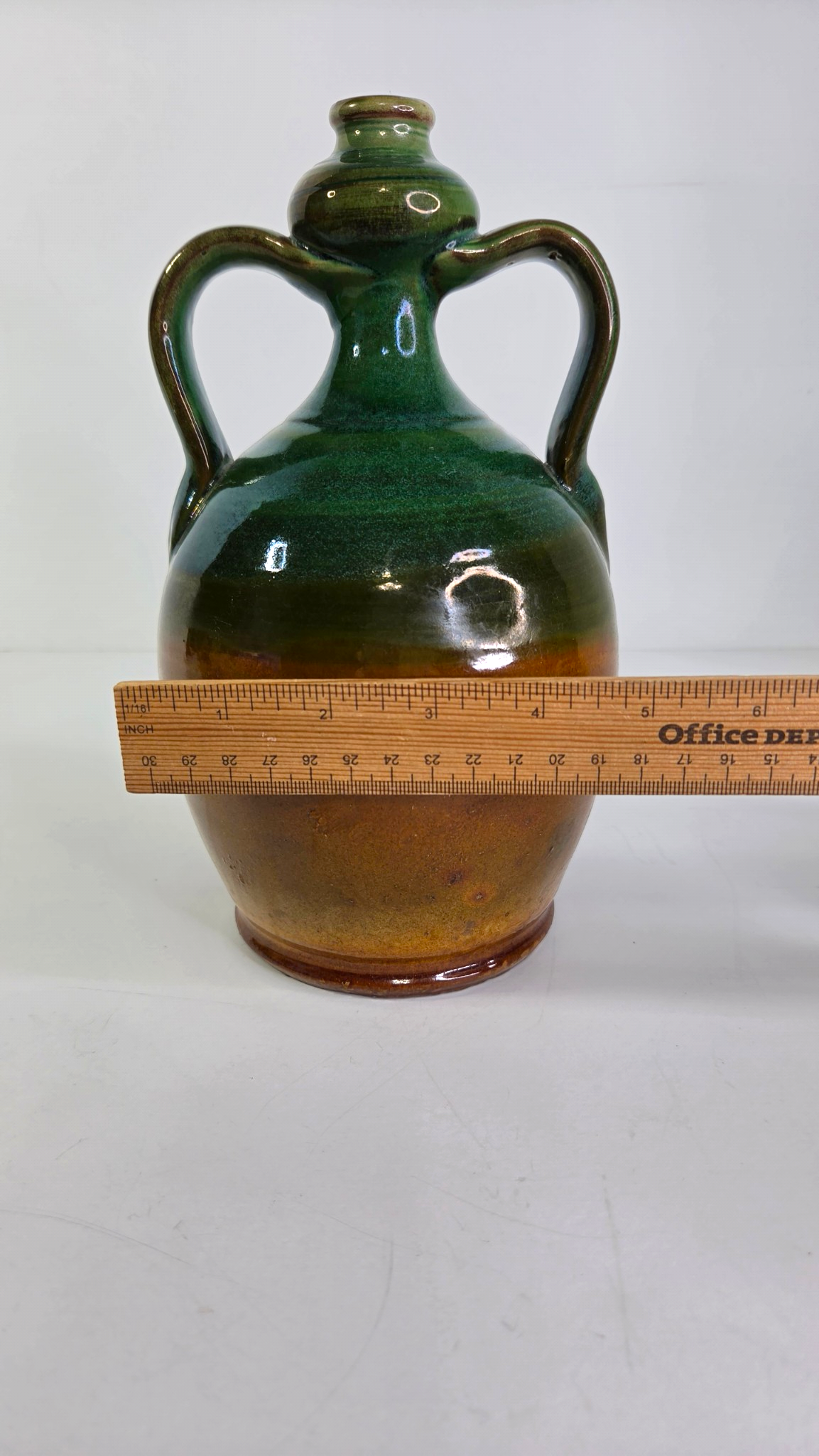 Oddly Darling Vintage handcrafted ceramic jug with dual handles, featuring a forest green and amber-brown glaze.