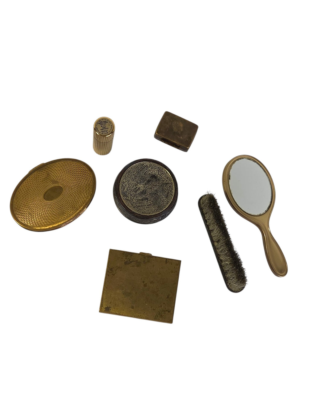 Backs of the vintage vanity lot: engine-turned gold-tone compact back, square compact bottom with marks, peacock box base, hand mirror, brush, pill box and lipstick label
